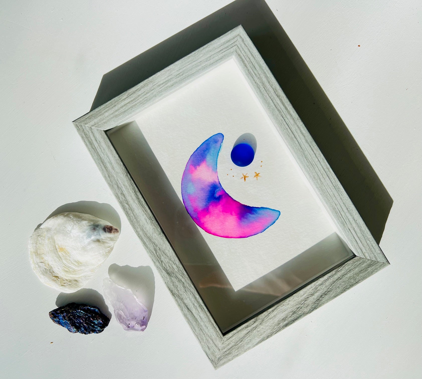 Original sea glass artwork featuring a beautiful watercolor crescent moon and a frosty piece of cobalt blue glass.   Artwork is displayed in a 4"x6" shadowbox frame. 